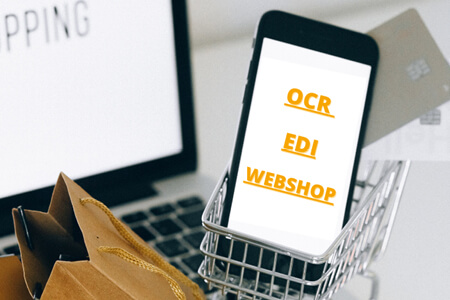 Blog| Smartphone on the display OCR, EDI, web store on a laptop with small shopping bags.