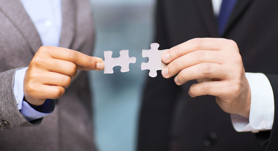 News Partnerschaft AFI und avvaneo News Partnerschaft AFI und avvaneo Teilansicht zweier Maenner in Anzug Zwei Puzzleteile in den Haenden